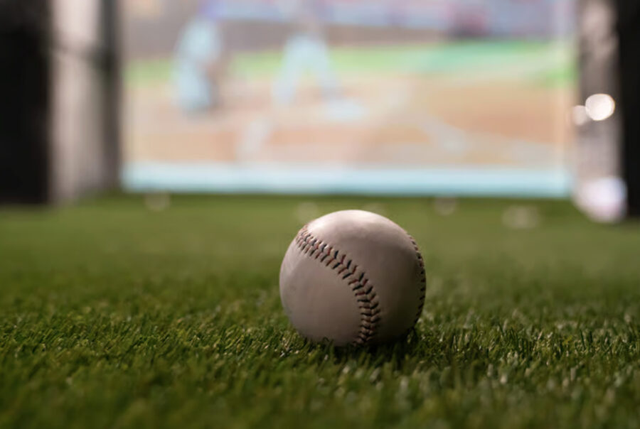 A baseball sitting on turf in a Batbox baseball simulator.